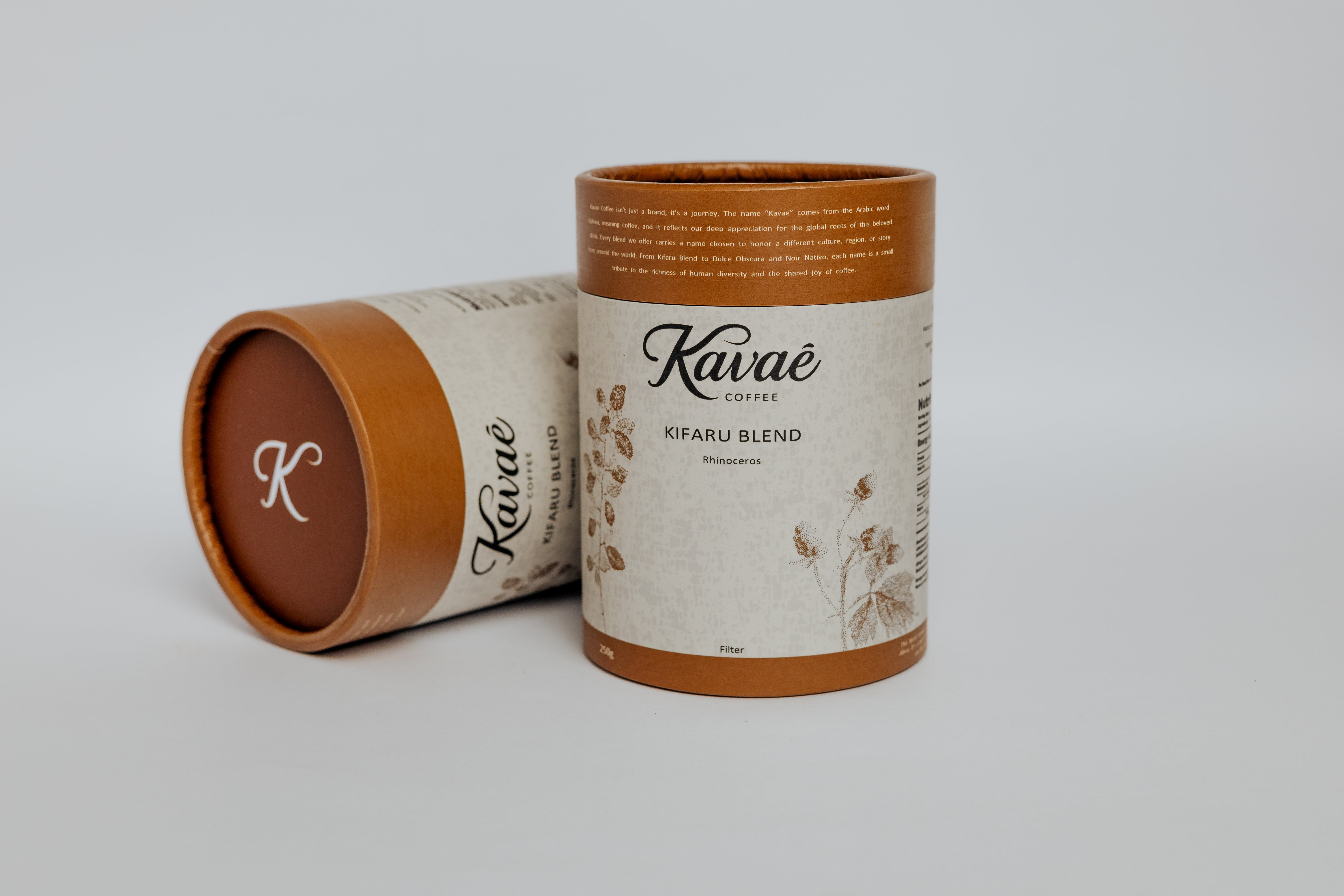 Two cylindrical coffee containers with 'Kavé' branding on a light gray background